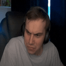 a man wearing headphones looks at the camera with a serious look on his face