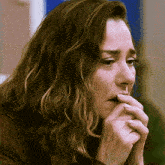 a close up of a woman 's face with her hand on her mouth