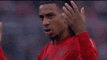 a man in a red shirt is making a gesture with his finger