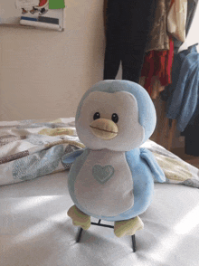 a stuffed penguin with a heart on its chest