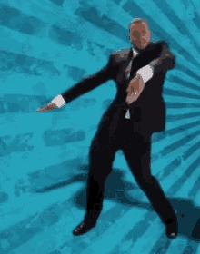 a man in a suit and tie is dancing against a blue background .
