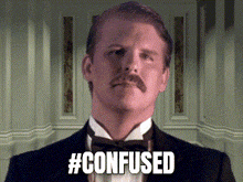 a man in a tuxedo with a mustache is looking at the camera and says `` confused '' .