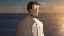 a man with glasses and a beard looks out over the ocean
