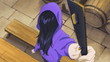 a person in a purple hoodie is holding a black object