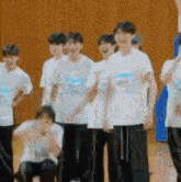 a group of young men are standing next to each other on a gym floor .