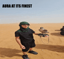 a man holding a bird in the desert with the words aura at its finest