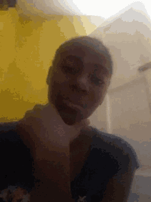 a man 's face is visible in a blurry photo with a yellow wall behind him