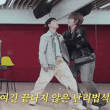 a couple of people standing next to each other in a room with korean writing