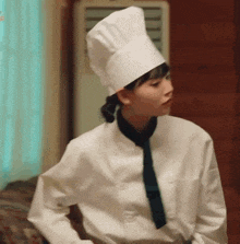a woman in a chef 's uniform and hat is dancing .