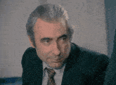 a man with gray hair and a suit and tie