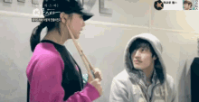 a man in a hoodie and a woman in a pink shirt are standing next to each other