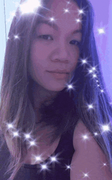 a woman with long hair is taking a selfie with a purple background
