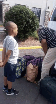 a boy holding hands with a man standing next to him