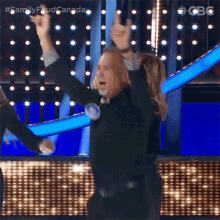 a man on a stage with his arms in the air .