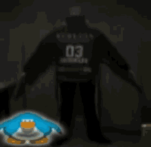 a man in a black shirt with the number 2 on it sits on the floor
