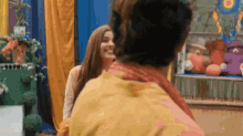 a man and a woman are standing next to each other in a room with stuffed animals in the background .