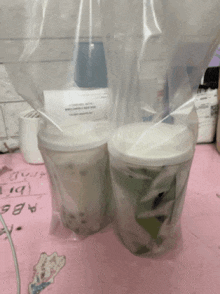 two cups are wrapped in plastic on a table