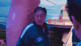 a man in a blue jacket with the number 100 on his chest