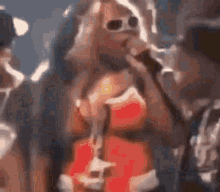 a woman in a red dress is singing into a microphone in a blurry photo .