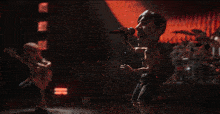 a man with a mustache is singing into a microphone in a dark room