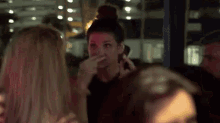 a woman is smoking a cigarette while talking on a cell phone .