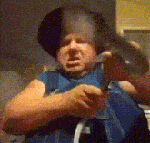 a man wearing a black hat is holding a blue backpack