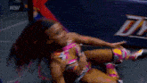 a woman with purple and blue hair is wrestling in a wrestling ring .