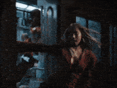 a woman in a red jacket is standing in a train
