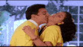 a man and a woman are kissing in a room .