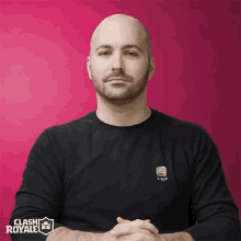 a man wearing a black clash royale shirt with his hands folded