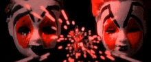 two clowns with red paint on their faces in a dark room