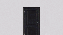 a man in a suit and tie stands in front of a door