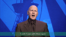 a bald man in a suit and tie says i wish i was with them again on a stage
