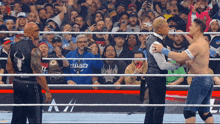 a man in a blue shirt that says chamber is standing in a wrestling ring