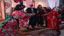 a group of people dressed up in costumes are dancing in a room