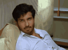 a man with a beard is laying on a bed