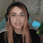 a woman wearing glasses and headphones is smiling for the camera