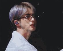 a close up of a man wearing glasses and a white shirt .