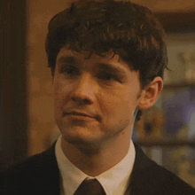 a man wearing a suit and tie is smiling
