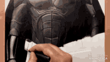 a close up of a person drawing a batman costume