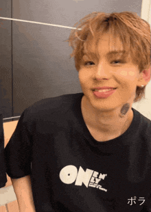 a young man is wearing a black shirt that says ok on it