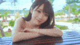 a woman is sitting at a table with her arms crossed and smiling at the camera