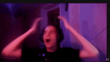 a man wearing headphones is making a funny face while playing a video game .