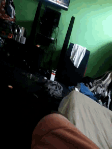 a person laying on a bed in a room with a tv on the wall