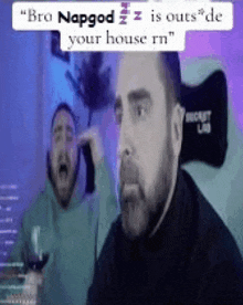 a man with a beard is sitting at a table with a glass of wine and another man screaming behind him .