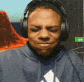 a man wearing headphones and a hoodie with the number 150 in the corner
