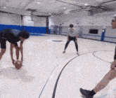 a group of basketball players are playing a game on a court with a logo on the wall that says ' a '