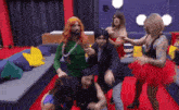 a group of people dressed up in costumes are dancing on a red carpet
