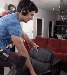 a man wearing headphones with the letter x on them adjusts a chair