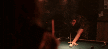 a man in a plaid shirt stands in a dark room